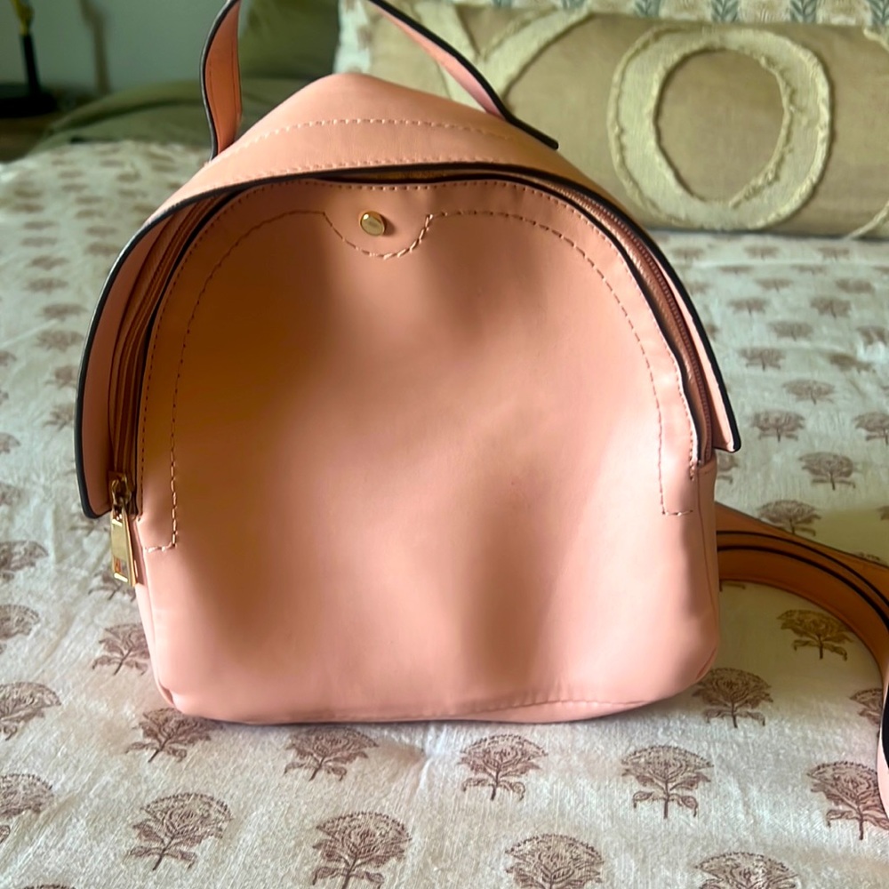 Salmon colored mini backpack purse.
